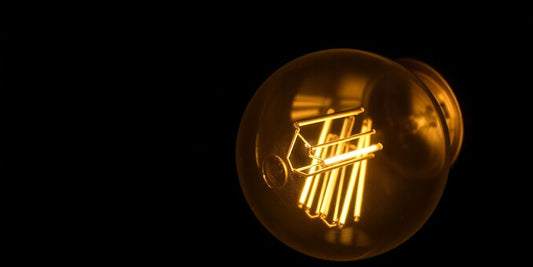 Glowing halogen filament bulb on a dark background.