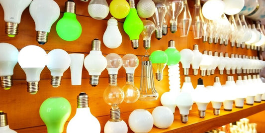 Assorted light bulbs on a wooden shelf.