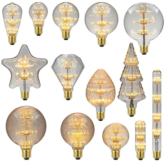 A collection of vintage LED bulbs with a starry firework design, showcasing various shapes and sizes with a warm glow visible through transparent glass.